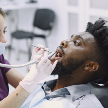 Brampton dentist doing routin dental exam & cleaning to their patient