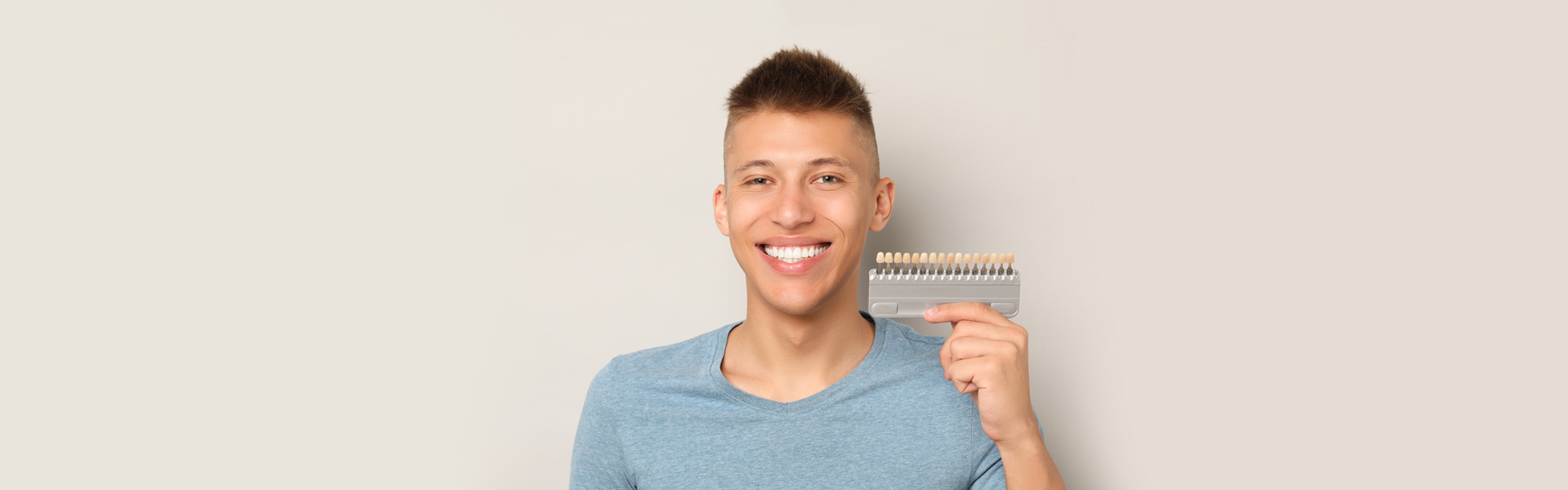 Boy holding a tooth veneers model