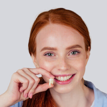 Girl holding her extracted tooth in Brampton